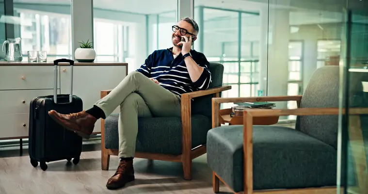 Man sitting in airport lounge on phone